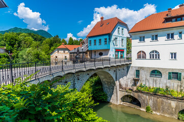 Fototapeta na wymiar A view towards the fourteenth century Capuchin Bridge over the Selca Sora River in the town of Skofja Loka, Slovenia in summertime