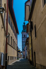A view up a narrow street towards the cathedral in the town of Skofja Loka, Slovenia in summertime