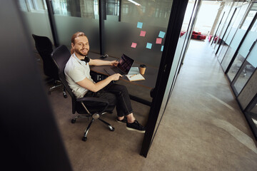 Fototapeta premium Handsome bearded guy comfortably settled down at his workplace