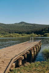 Fototapeta na wymiar wooden pier lake surrounded by mountains, Slovenia. The concept of summer holidays, holidays