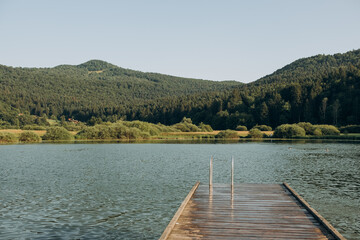 wooden pier lake surrounded by mountains, Slovenia. The concept of summer holidays, holidays