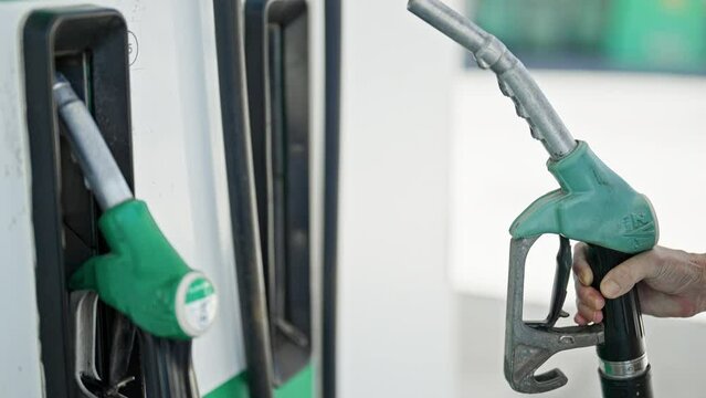 Middle age woman holding fuel at petrol station