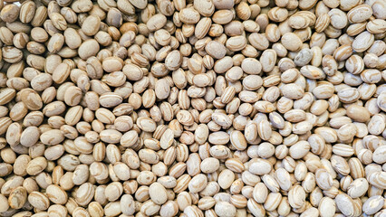 Beans, many beans scattered over a surface, natural light, selective focus.