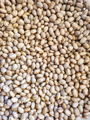 Beans, many beans scattered over a surface, natural light, selective focus.