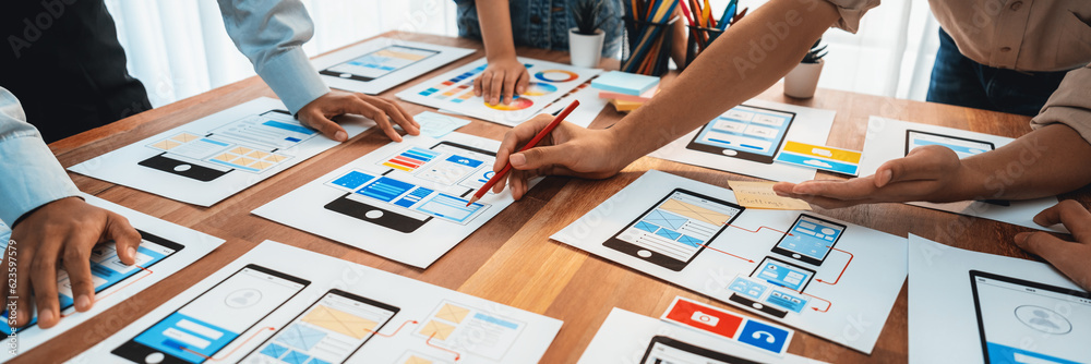 Poster Panorama shot of front-end developer team brainstorming UI and UX designs for mobile app on paper wireframe interface. User interface development team planning for user-friendly UI design. Scrutinize