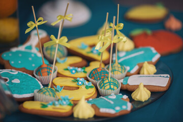 Fototapeta premium Colorful candies with baby and newborn symbol. Candy bar with Sweets in different shapes for children. Cake, cookies, creamy muffins, fresh berries for celebratory birthday. Baby Shower party decor.