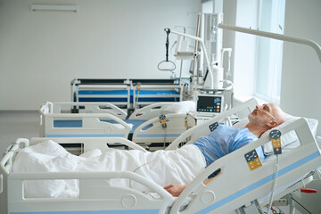 Man lying on the bed in intensive care unit