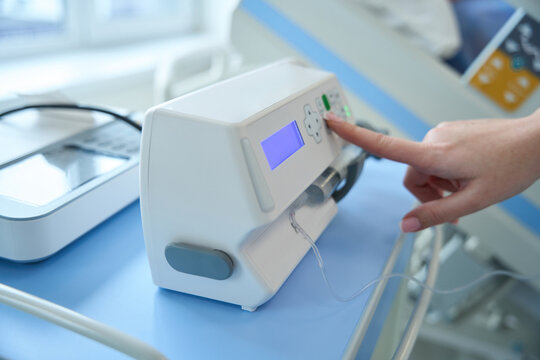 Doctor is adjusting syringe pump in hospital - Powered by Adobe