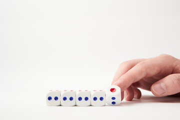 Hand turns dice and changes the expression on white background 
