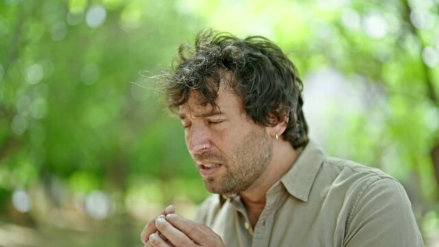 Young hispanic man with pollen allergy at park