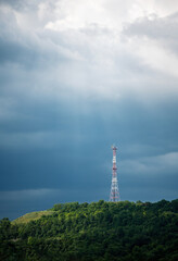 Obraz premium radio tower on a hill on storm sky background