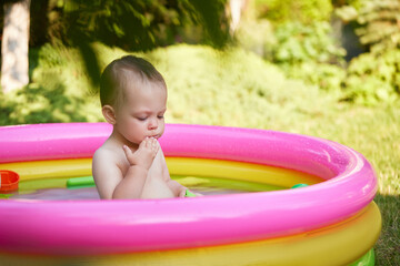 cute baby girl swimming in kid inflatable pool