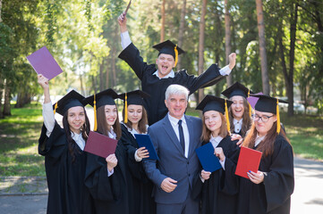 University professor and seven graduates rejoice at graduation. 