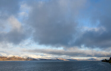 View to calm water surface of lake Sevan and snow capped mountains in distance. Picturesque landmark of Armenia