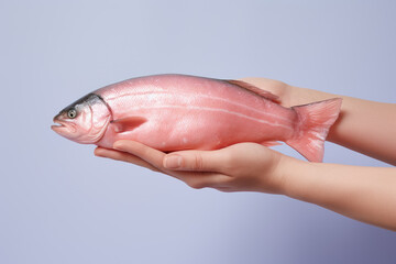 Fototapeta premium Hands holding fresh salmon on pastel background, fresh food ingredients, Healthy food