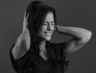 Emotional confused beautiful woman holding the head the hands with clenched her teeth and thinking hard question on studio background. Closeup portrait.