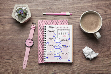 Self organization with bullet journal. Notebooks, wristwatch and cup with coffee on wooden table, flat lay
