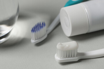 Fototapeta na wymiar Plastic toothbrush with paste on grey background, closeup