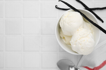 Delicious ice cream, spoon and vanilla pods on white tiled table, flat lay. Space for text