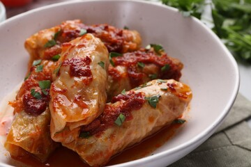 Delicious stuffed cabbage rolls cooked with homemade tomato sauce on table, closeup