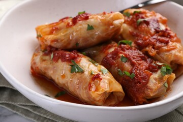 Delicious stuffed cabbage rolls cooked with homemade tomato sauce on table, closeup