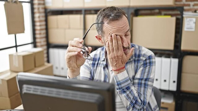 Middle age man ecommerce business worker using computer stressed at office