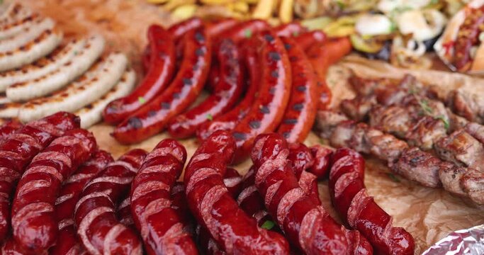 Food festival with food stall kiosk, open-air outdoor fair market, assortment of different traditional European grilled barbecued street food with sausages, bbq, chicken, pork and lamb on a large pan