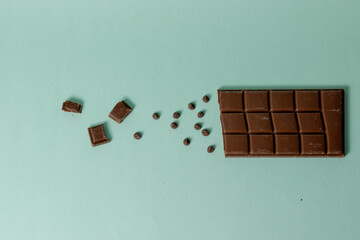 Chocolate bar getting rid of little by little until reaching the end of the image. Turquoise background.