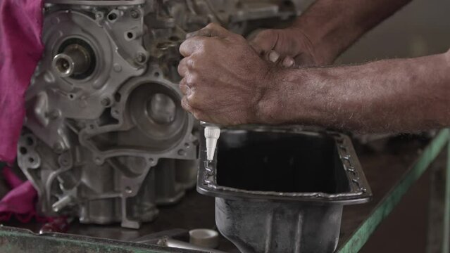 Car Engine Crankcase Cover Being Repaired With Sealing Liquid Gasket In The Repair Shop Footage.