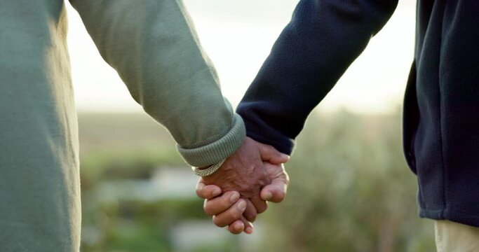 Couple, holding hands and walking at a park outdoor with love, commitment and care in summer. Closeup of a man and woman together on an adventure, travel and romantic stroll for freedom or to relax
