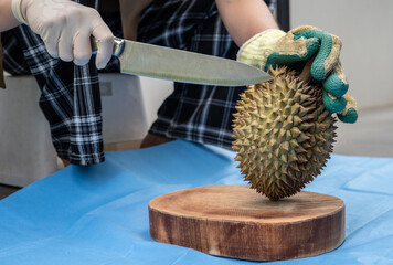 Someone trying to removing Durian shell by knife. Durian is the 