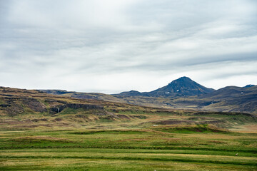 Fototapeta na wymiar View across the grassy plains with a volcanic crater in the Snæfellsnes peninsular in west Iceland