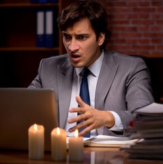 Businessman working late in office with candle light