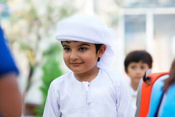 Boy in Kandura at school Young Arab student with classmates waiting in line ideal for Emirati,...
