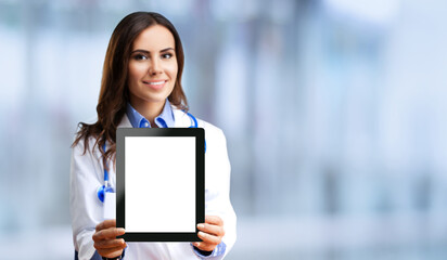 Portrait of happy smiling young female doctor showing tablet pc with blank copy space area for...