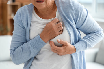 Mature woman having heart attack at home, closeup