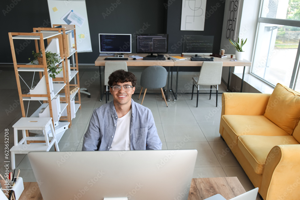 Canvas Prints Male programmer working with computer at table in office