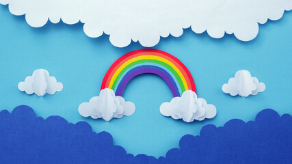 Rainbow on blue sky with clouds  made of paper cutout. paper art creative background.