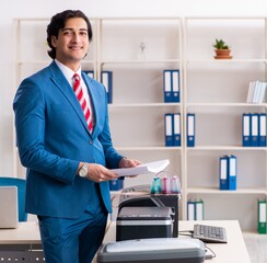 Young employee making copies at copying machine