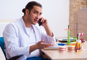 Young male dentist working in the clinic