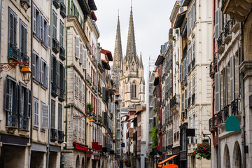 Alley with old buildings and cathedral towers in the background in the city of Bayonne in the south of France.