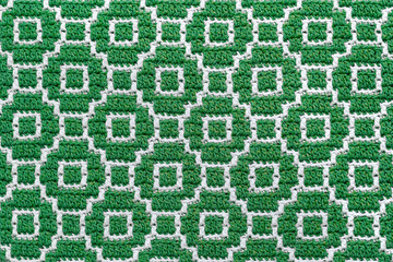 Abstact knitted background. Crochet mosaic pattern. Seamless green white crochet texture.