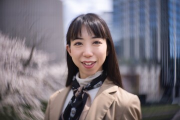 A swirly portrait of Japanese woman behind cherry blossom closeup