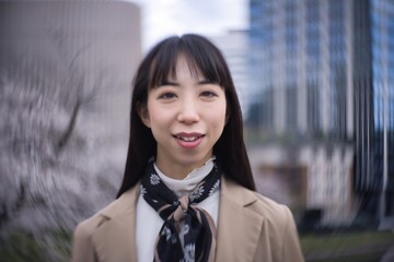 A swirly portrait of Japanese woman behind cherry blossom closeup