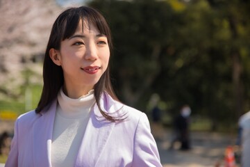 A portrait of Japanese woman behind cherry blossom in Tokyo copyspace