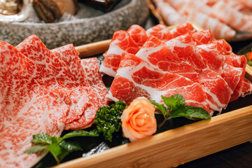 Premium Rare Slices pork with high-marbled texture on circle wooden plate served for hot pots and...