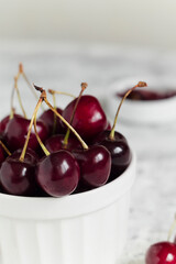 Fresh organic red cherries in a white bowl on the table. Helthy eating.