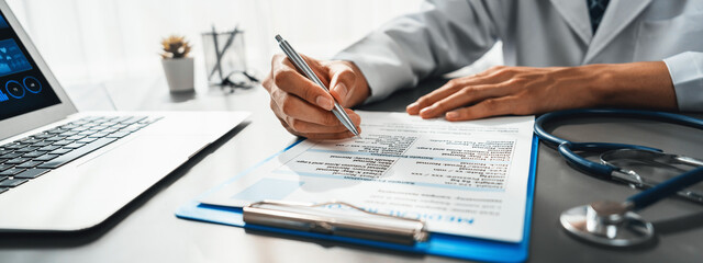 Doctor carefully review detailed medical report with laptop and diagnosing illness for effective...