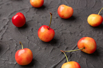 Many sweet yellow cherries on black background