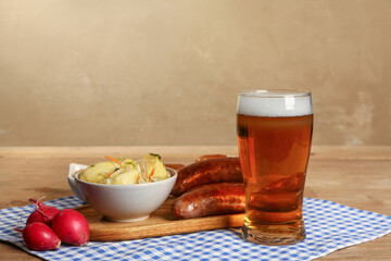 Glass of cold beer and different snacks on wooden background. Oktoberfest celebration